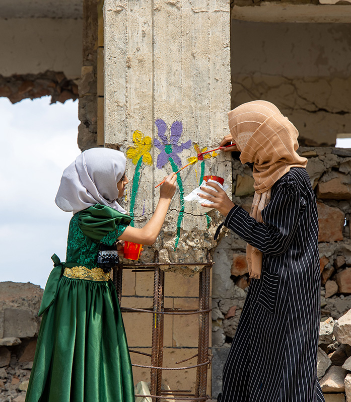 Träume statt Trümmer: Kinder malen Blumen an eine zerstörte Schule im Yemen. Träume statt Trümmer: Kinder malen Blumen an eine zerstörte Schule im Yemen.