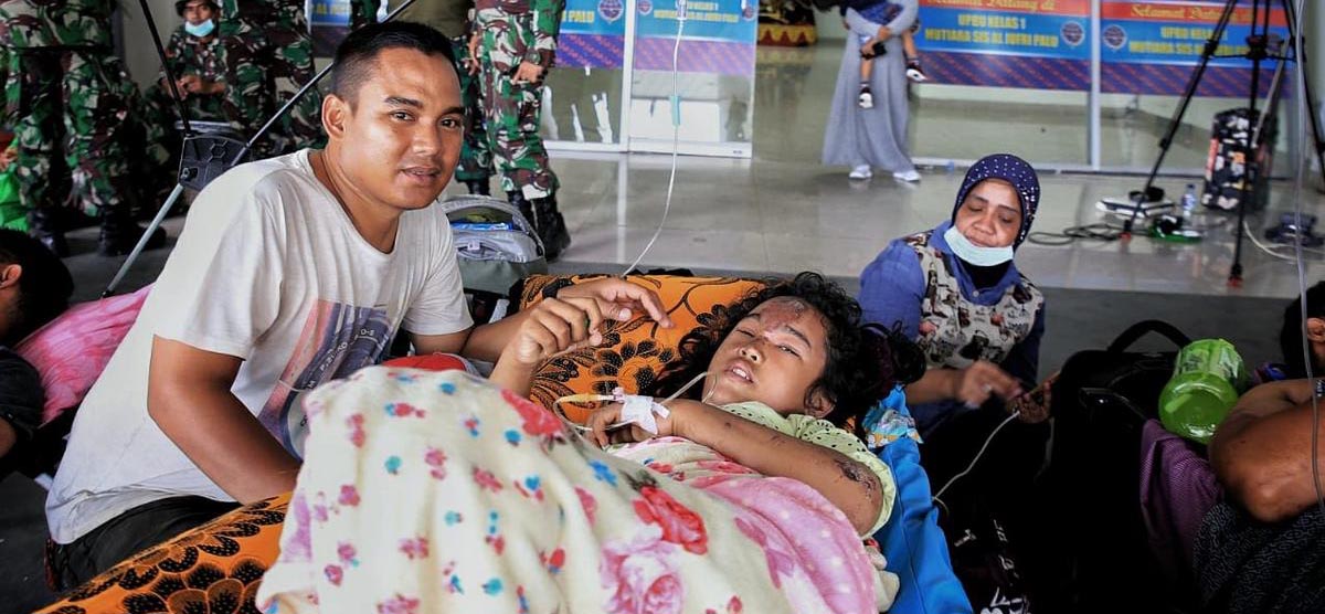 Ein schwer verletztes Mädchen liegt in einem Flughafen auf einer Krankenliege