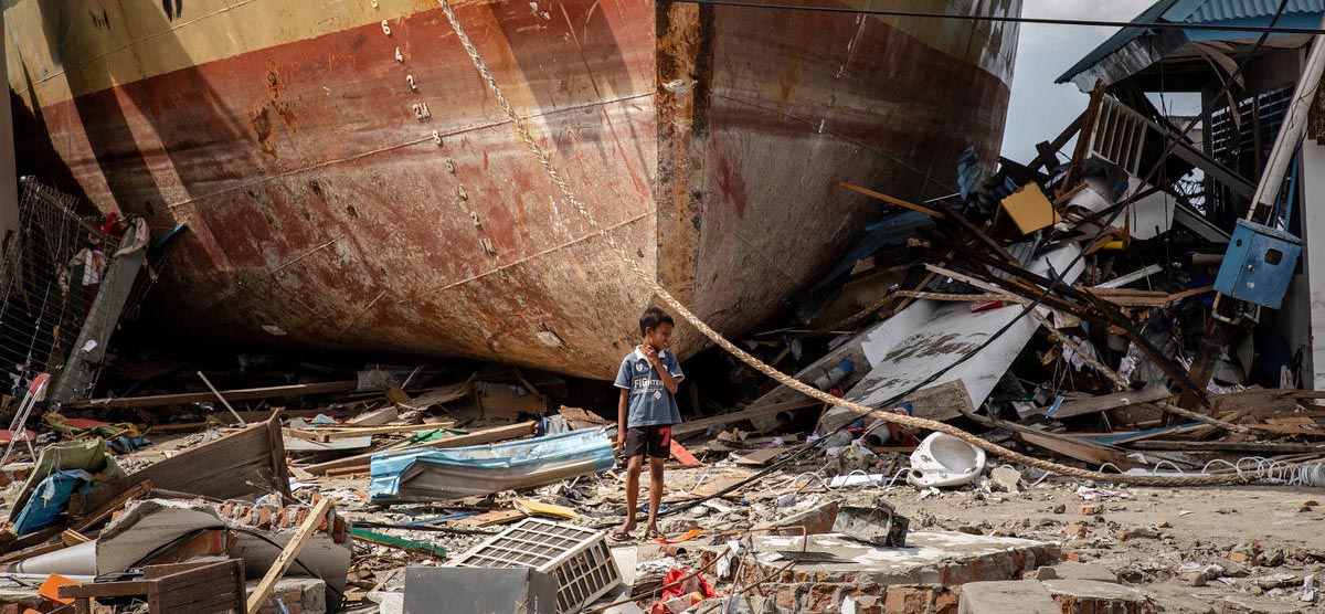 Ein Junge steht nach dem Tsunami auf Sulawesi in den Trümmern vor einem gestrandeten Schiff. ©Ulet Ifansasti/Getty Images