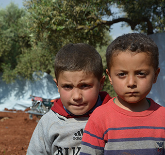 Hasan* und sein Bruder Kareem* aus Idlib in Syrien. Sie mussten mit ihrer Familie fliehen, nachdem ihr Dorf und die Schule bombardiert wurden.