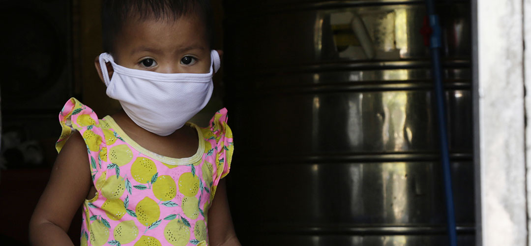 Ein einjähriges Kind auf den Philippinen trägt eine Atemschutzmaske, um sich vor Corona zu schützen. © Save the Children / Lei Tapang