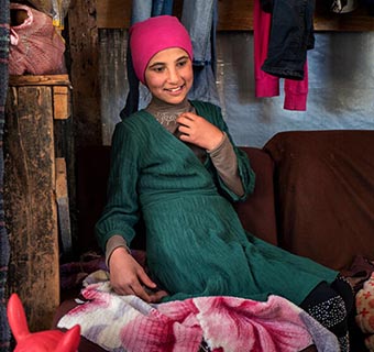 Die heute 13-jährige Amal* sitzt in einem von ihrer Familie improvisierten Wohnzimmer in einer informellen Siedlung für Geflüchtete im Libanon. © Dominic Nahr / Save The Children 