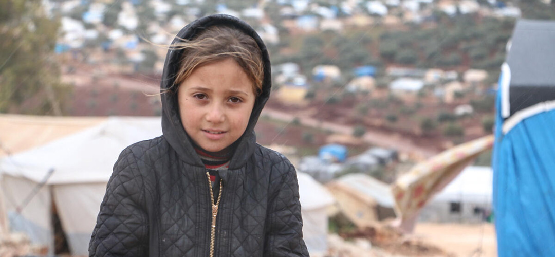 Die siebenjährige Lara* vor dem Zelt, in dem sie in einem Camp in Nordwestsyrien derzeit mit ihrer Familie lebt.