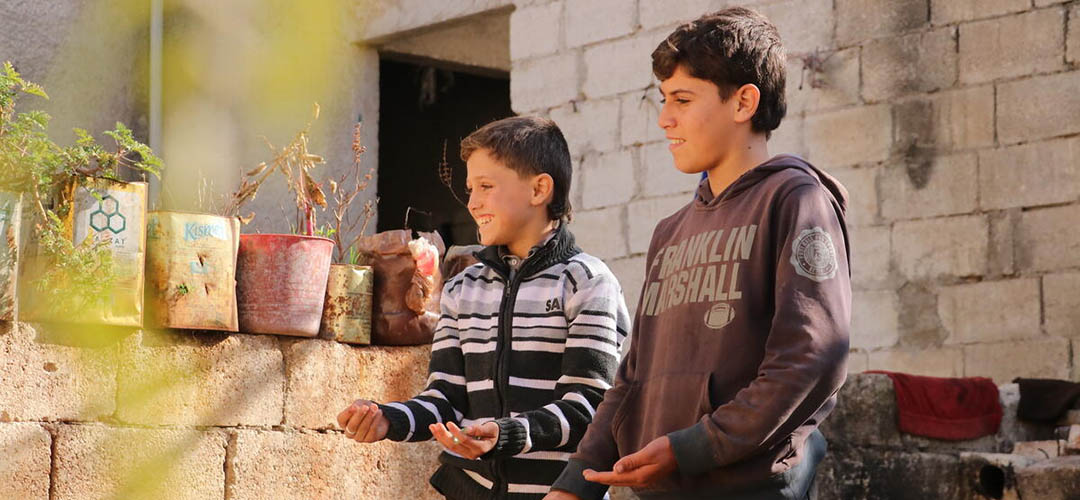 Ziad*, zehn Jahre alt, und sein Bruder Fadi*, 12 Jahre alt, beim Spielen vor ihrem Zuhause in Syrien. 