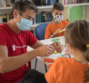 Save the Children Mitarbeiter mit Kindern in einem Punto Luce-Bildungszentrum in Italien.