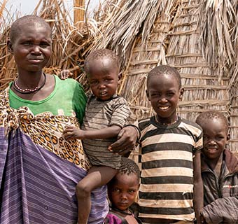 Ngicwae Emoni Amodoi mit einem Teil ihrer Familie in Turkana, Kenia. Zwei ihrer Töchter sind aufgrund akuter Unterernährung in medizinischer Behandlung durch Save the Children.