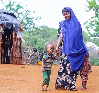 Zeitun* mit ihren beiden jungen Söhnen Abdirahman* und Farhan* in ihrem Heimatdorf in Kenia. Ein mobiles Gesundheitsteam hilft den beiden Jungen dabei, trotz Muskelschwäche richtig Laufen zu lernen.