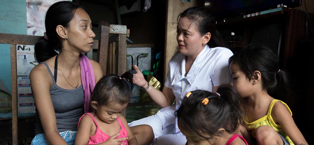 Hebamme Grace Chelo Amarez berät die junge Mutter Jessica bei einem Hausbesuch in dem ärmeren Viertel in der Gemeinde Malabon City auf den Philippinen.