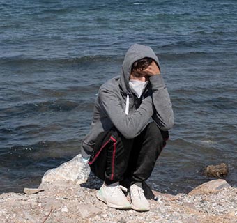 Dieser Jugendliche ist auf seiner Flucht nach Europa auf Lesbos, Griechenland, gestrandet. Sein Schicksal teilen Tausende von Geflüchteten, die auf der Insel und an den EU-Außengrenzen in überfüllten Camps ausharren.