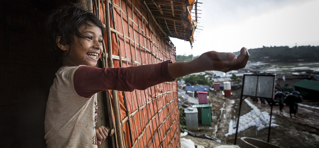 Ein elfjähriges Mädchen spielt mit dem Monsunregen, der über ein Flüchtlingslager für Rohingya in Cox's Bazar, Bangladesch, fällt.