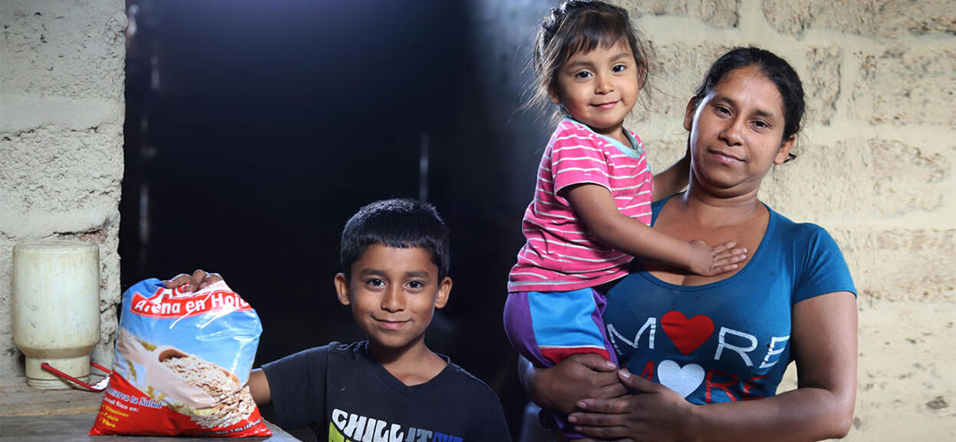 Jenny, 33 Jahre alt, und ihre beiden Kinder aus Nicaragua in ihrer Wohnung mit Lebensmitteln, die sie mit Lebensmittelgutscheinen von Save the Children gekauft haben.