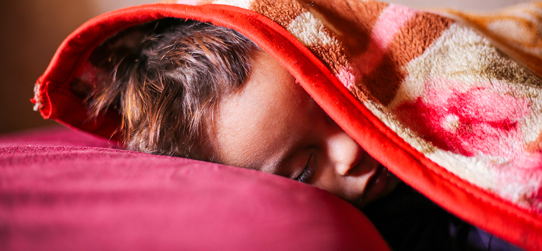 Aras* Zwillingsbruder Milad*, 18 Monate, schläft im Zimmer seiner Familie. © Michal Przedlacki/ Save the Children