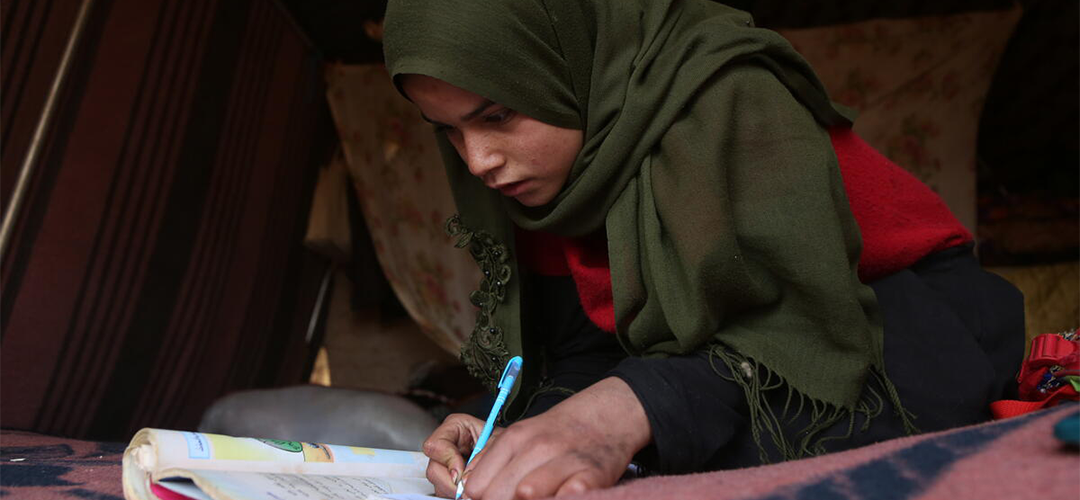 Hiba* versucht, durch Lesen und Schreiben mit dem Lernen Schritt zu halten und hofft, dass sie bald wieder die Schule besuchen kann.