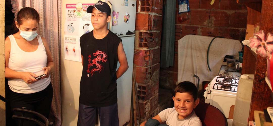 Luis* mit seiner Familie im Hauptraum ihrer Wohnung, der als Küche, Wohn- und Lernzimmer herhalten muss. © Daniela Gómez Arguinzones / Save the Children 