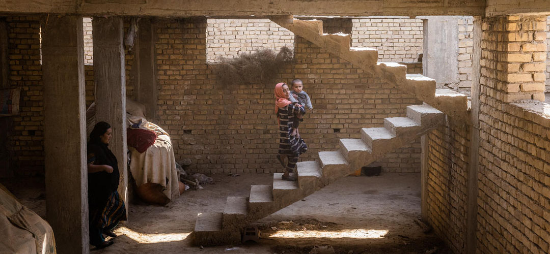 Laalah* geht mit ihrem kleinen Bruder Faakhir* die Treppe in ihrem baufälligen Haus in Afghanistan hinauf. © Jim Huylebroek / Save The Children