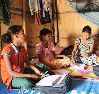 Vier geflüchtete Rohingya-Mädchen lernen gemeinsam in einem Camp in Bangladesch.