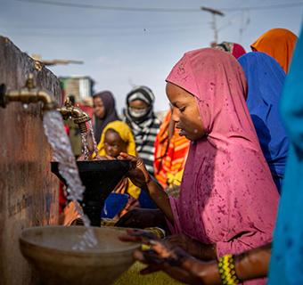 Ladan* (10) beim Wasser holen in Somalia. Ihr kleiner Bruder war schwer mangelernährt, konnte jedoch auf der lokalen Gesundheitsstation erfolgreich behandelt werden. Save the Children unterstützt die Familie außerdem mit Bargeltransfers. © Muatafa Saeed / Save the Children