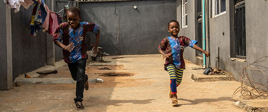Zwei Geschwister rennen in Nigeria © Yagazi Emezi / Save the Children
