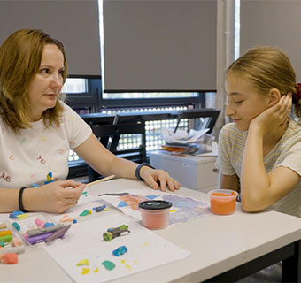 Gemeinsam mit der zwölfjährigen Daria* aus der Ukraine malt die Psychologin, denn durch Bilder können Kinder ihre Gefühle besser ausdrücken.