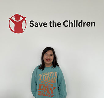 Anita unter dem Logo von Save the Children