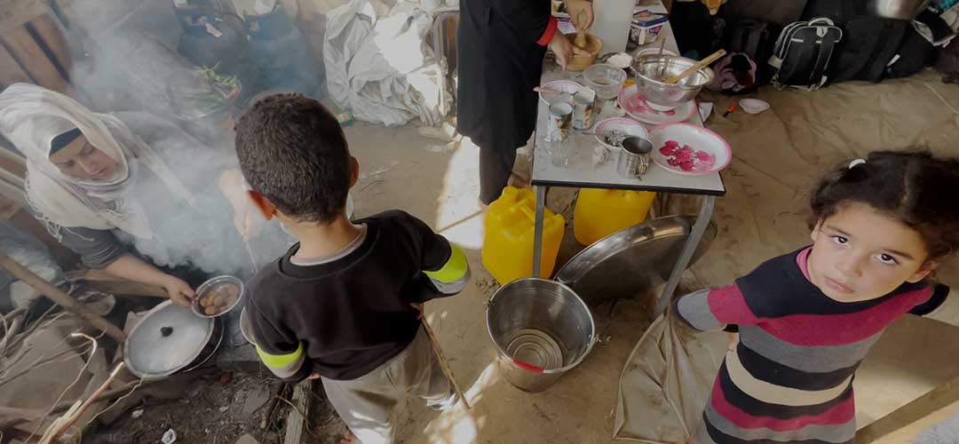 Eine Mutter kocht in ihrer Zeltunterkunft im Süden Gazas