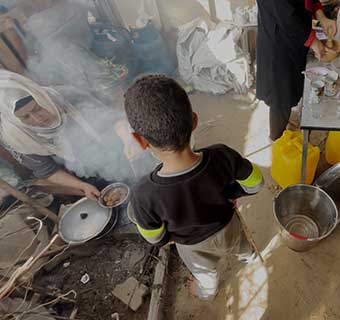Eine Mutter kocht in ihrer Zeltunterkunft im Süden Gazas