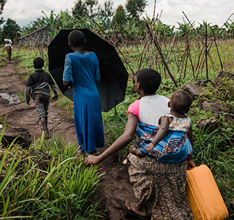Vier Kinder in der Demokratischen Republik Kongo laufen hintereinander, um Wasser zu holen. © Hugh Kinsella Cunningham /Save the Children