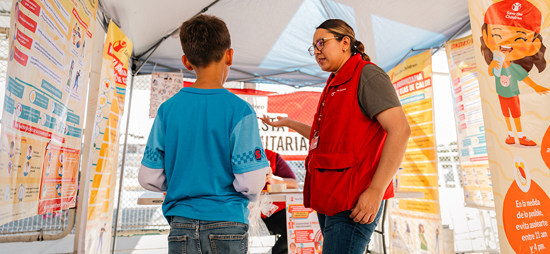 Eine Mitarbeiterin von Save the Children erklärt einem Kind die Folgen einer Hitzewelle. © Miguel Vera / Save the Children Mexiko Eine Mitarbeiterin von Save the Children spricht mit einem Kind