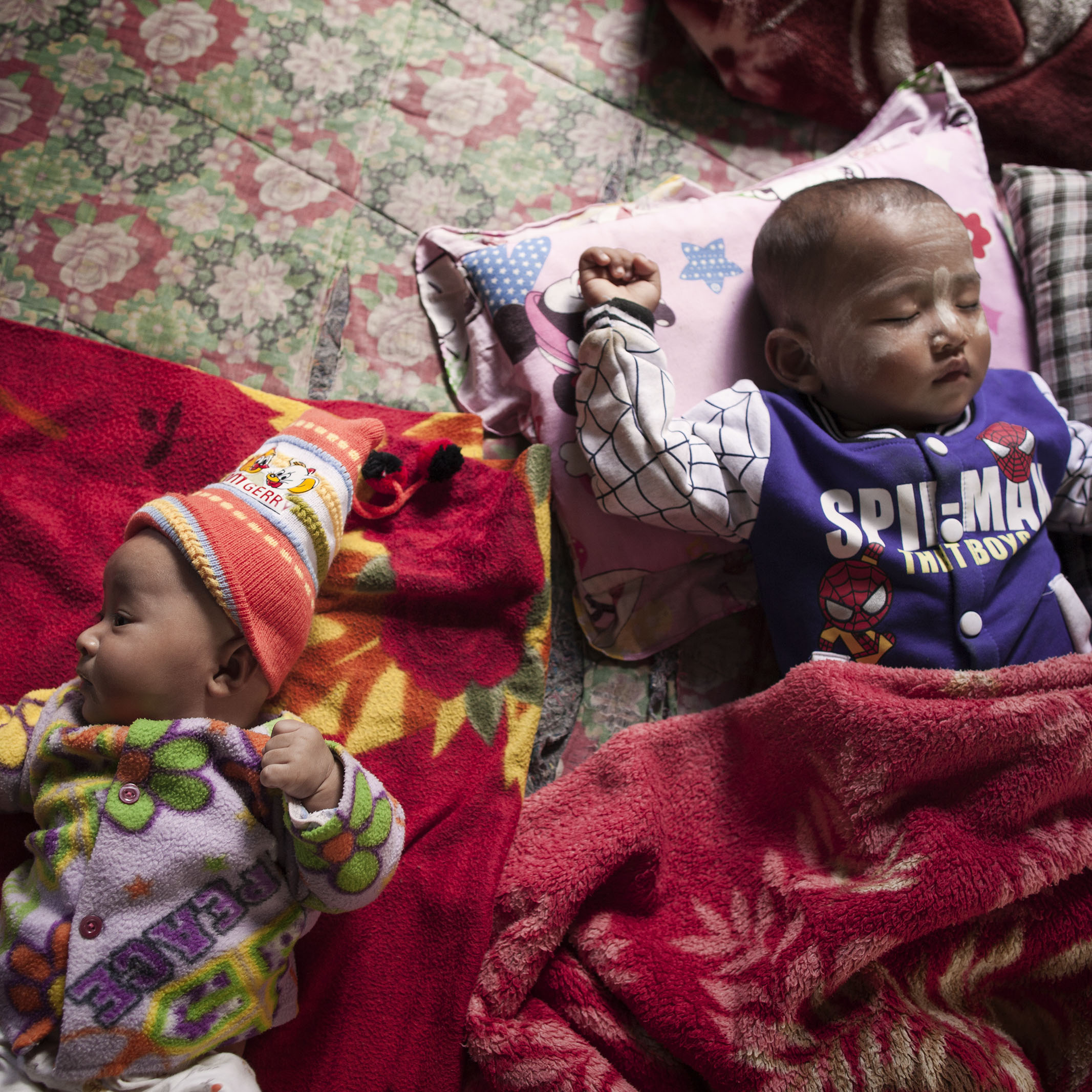 Die zwei Monate alte Kyaut Shin Thant teilt sich ein Bett mit ihrem Cousin Thant Sin Oo, 18 Monate alt. Ihre Mutter erhielt von Save the Children finanzielle Notfallunterstützung.