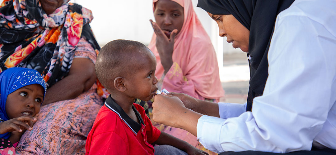 In der Klinik bekam Abdi eine nährstoffreiche Erdnusspaste: Plumpynut. © Mustafa Saeed / Save the Children Ein kleiner Junge wird von einer Gesundheitshelferin gefüttert.