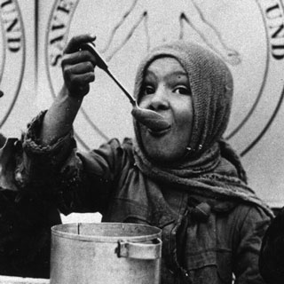 Kind isst aus Topf schwarz weiß