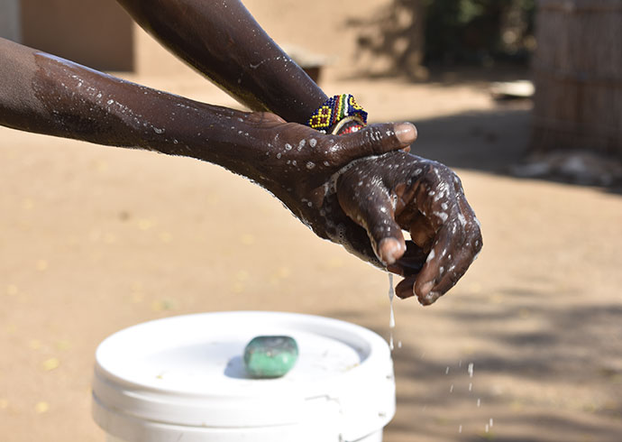 Eine Frau im Südsudan wäscht sich dir Hände. © Tito Justin / Save the Children