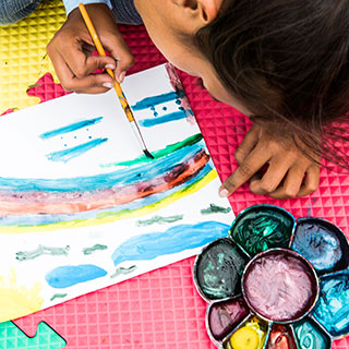 Ein Kind malt während eines Projekts von Save the Children