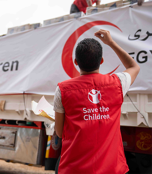 Mitarbeitende von Save the Children in Ägypten beladen Lastwagen mit dringend benötigten Hilfsgütern für Gaza. © Save the Children Ein männlich gelesener Mitarbeiter von Save the Children steht vor einem Truck mit Hilfsgütern.