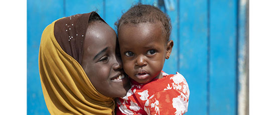 Fatun mit ihrer kleinen Schwester Fatima im Arm. © Kate Stanworth / Save the Children
