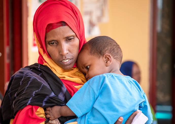 Ayan*, 30 Jahre alt, mit ihrem acht Monate altem Sohn Hamdan* im Gesundheitszentrum eines Geflüchtetencamps in Somalia. © Jonathan Hyams / Save the Children Ayan*, 30 Jahre alt, mit ihrem acht Monate altem Sohn Hamdan* im Gesundheitszentrum eines Geflüchtetencamps in Somalia.