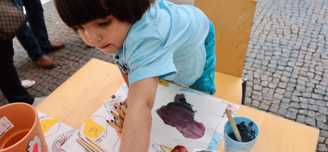 Ein kleiner Junge malt ein Bild. 