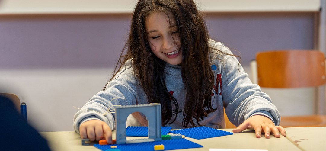 LEGO hilft: Grundschulkindern im Projekt „Mit Spiel zum Ziel“ © Mauro Bedoni / Save the Children Ein Mädchen baut aus Lego-Bausteinen einen Torbogen.