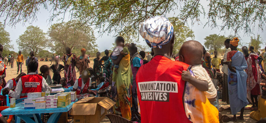 Gesundheitshelferin Ayen* unserer mobilen Gesundheitsstation im Südsudan hält ein Baby, das gerade geimpft wurde. © Ezibon Saadalla Khamis / Save the Children Eine Gesundheitshelferin hält ein Baby.