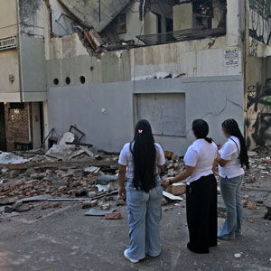Nach dem Erdbeben in Kolumbien: Viele Häuser wurden zerstört. © Photo by JOAQUIN SARMIENTO / AFP via Getty Images Drei Frauen stehen vor einem zerstörten Gebäude nach dem Erdbeben in Kolumbien.
