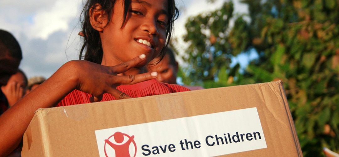 Ein Mädchen freut sich über ein Nothilfepaket von Save the Children